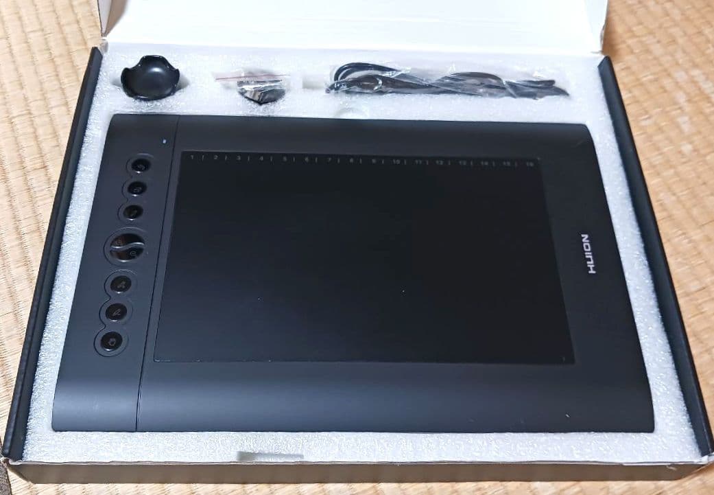 HUION H610 PRO digital tablet placed in its box with included accessories visible.