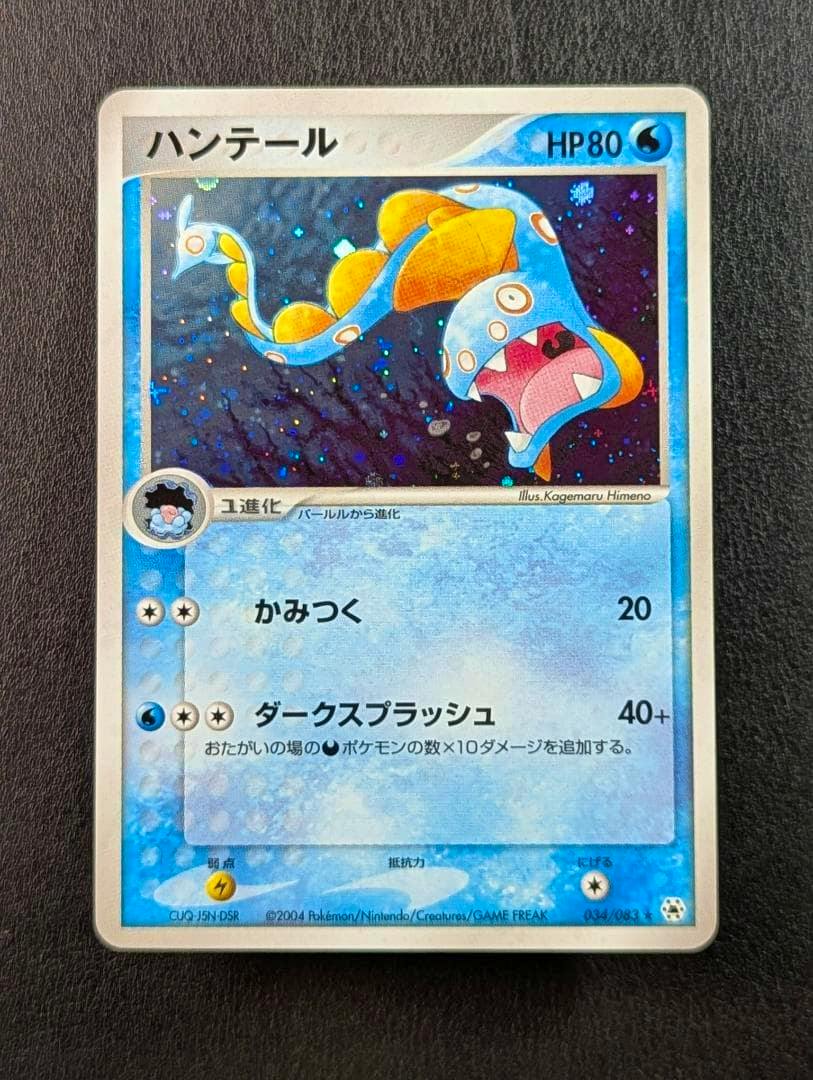 Photograph of the front of the Japanese ハンテール trading card (034/083) showing the holographic artwork and card text.