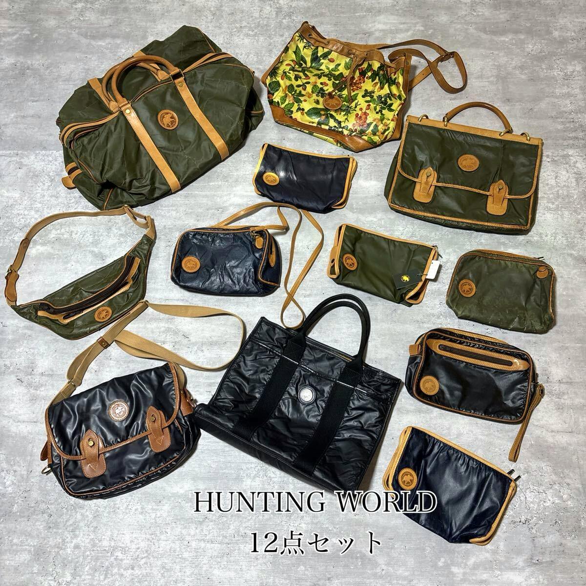 Twelve Hunting World bags and pouches arranged on a light floor showing various green and black canvas pieces with leather trim.
