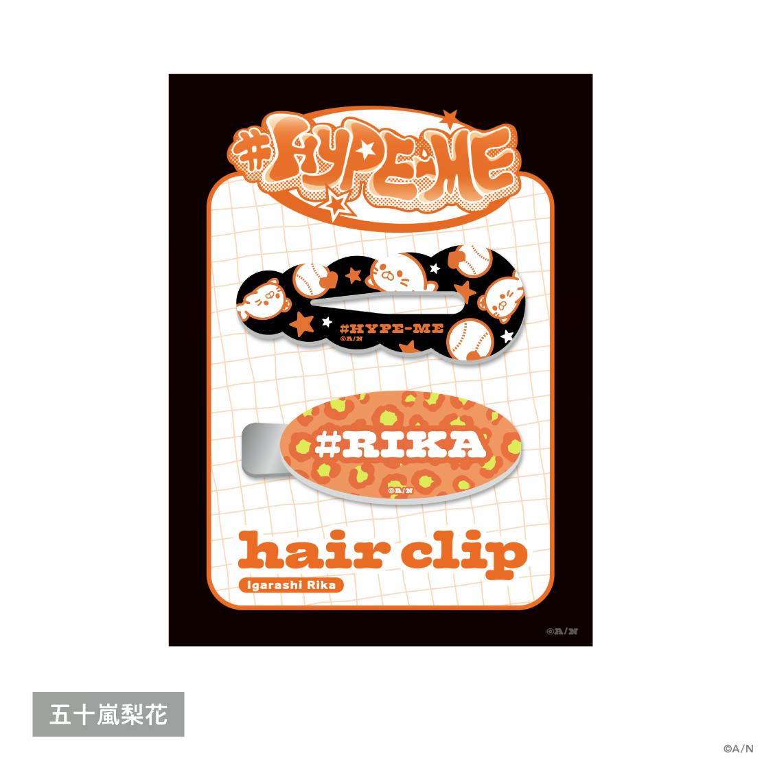 Packaged hair clip set on a backing card showing two hair clips, one black patterned clip and one orange oval clip labeled "#RIKA".