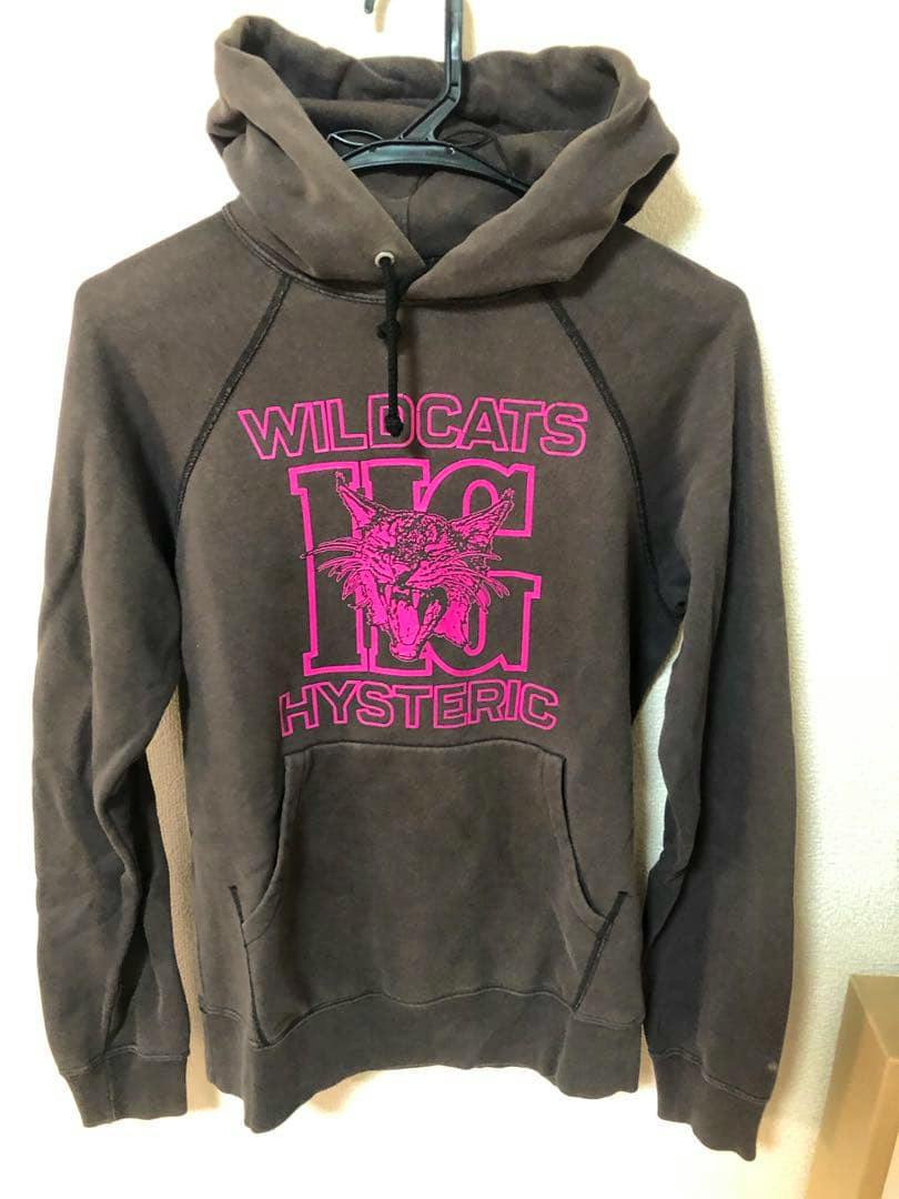 Brown cotton hoodie shown hanging on a hanger with bright pink "WILDCATS" and "HYSTERIC" text and a snarling cat graphic on the front.