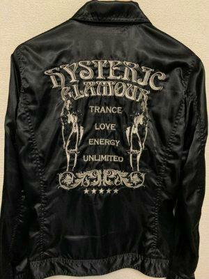 Back view of a black men's jacket showing large white embroidered HYSTERIC GLAMOUR text and twin-girl style embroidery.