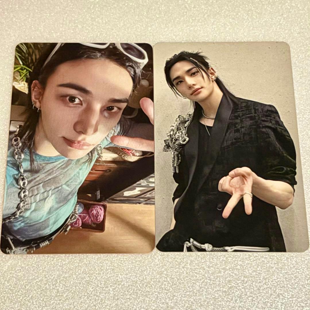 Two rectangular photocards placed side by side showing portrait images of a young man in casual and formal outfits on a textured surface.