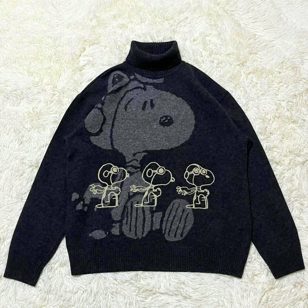 Dark wool turtleneck sweater laid flat showing a large Snoopy graphic and three smaller Snoopy figures on the front.
