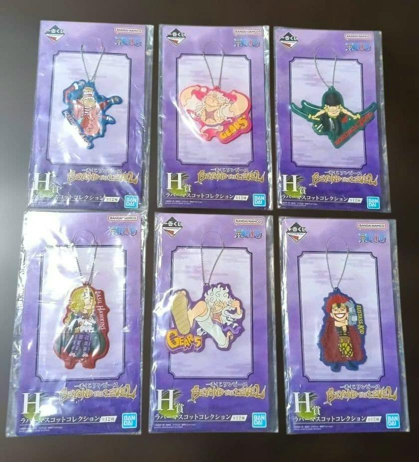 Six One Piece rubber keychain mascots in their purple backing cards, arranged two rows of three and still in plastic packaging.