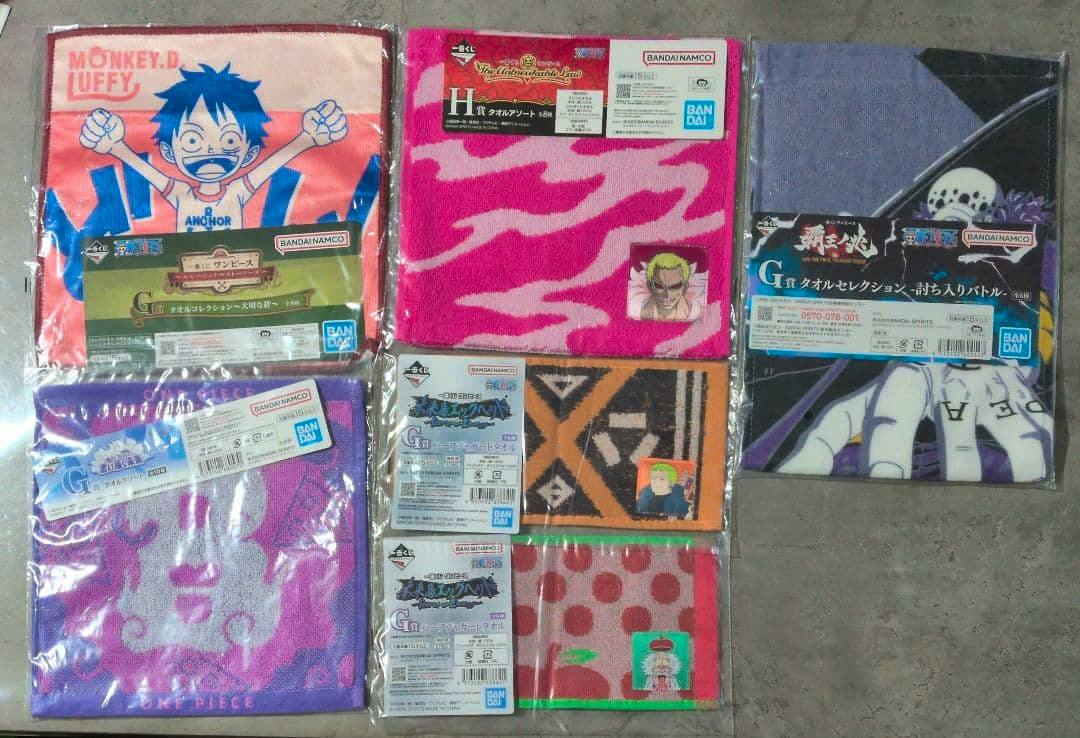 Unopened polyester One Piece hand towels in original packaging with various character designs visible, arranged on a surface.