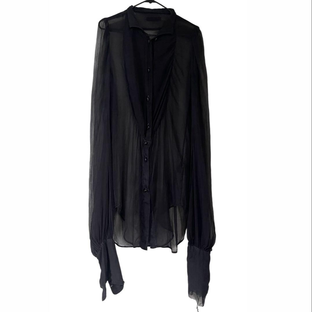 Black sheer silk tuxedo shirt hanging on a hanger against a white background.