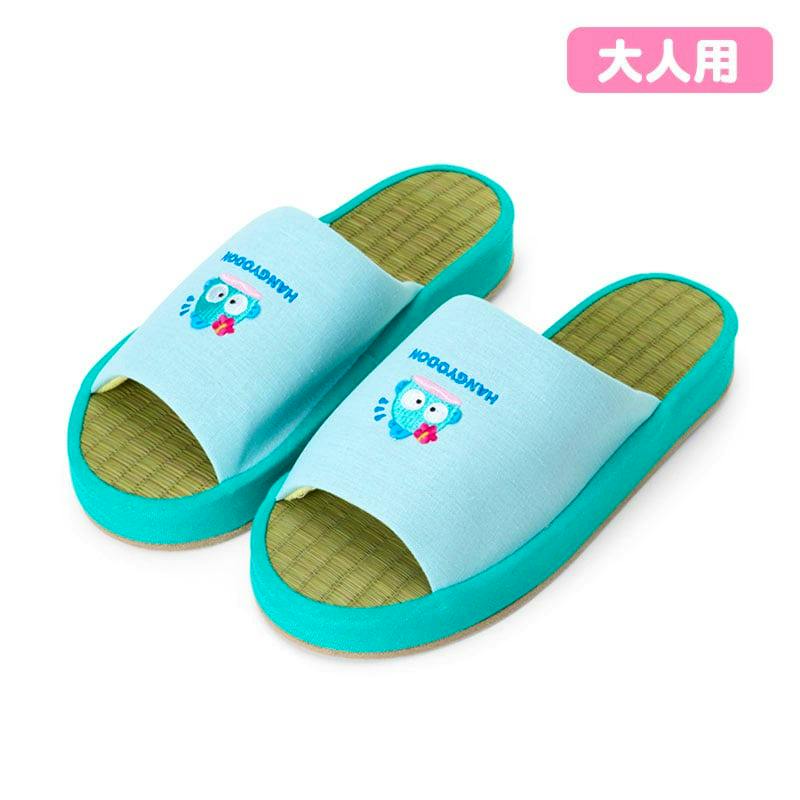 Pair of light blue igusa slippers with green woven footbeds and a small cartoon character on the straps.