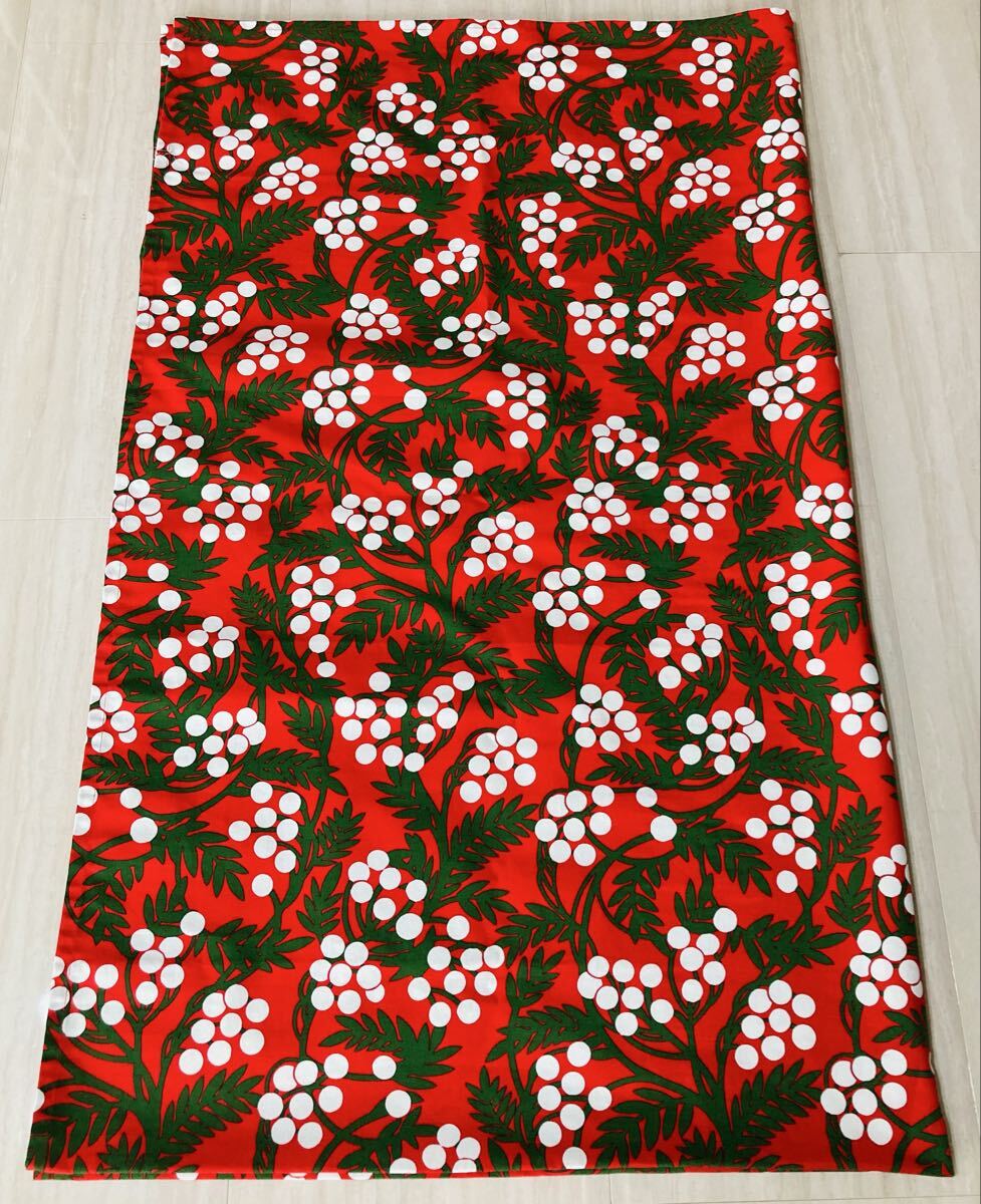 Red IKEA VINTERFINT tablecloth with white berry clusters and green leaves laid flat.