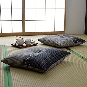 Two black Japanese-patterned cushions (set of 2) on a tatami mat with a tea set and shoji screen in the background.