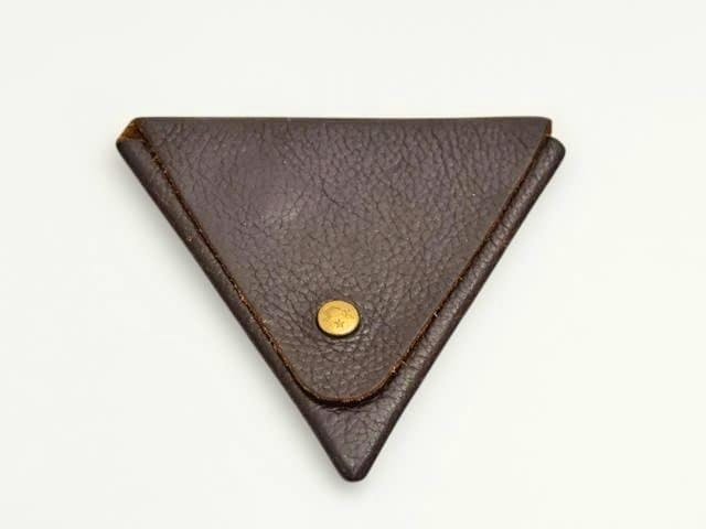 Triangular dark brown leather IL BISONTE coin case with a brass snap button on a white background.