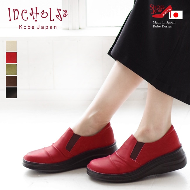 Red leather slip-on comfort shoes shown on a model's feet against a light background.