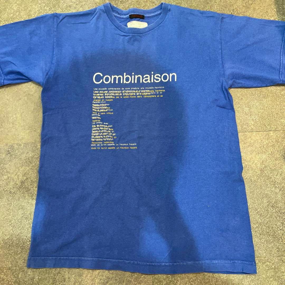 Blue men's cotton T-shirt laid flat showing the front with the word "Combinaison" printed.