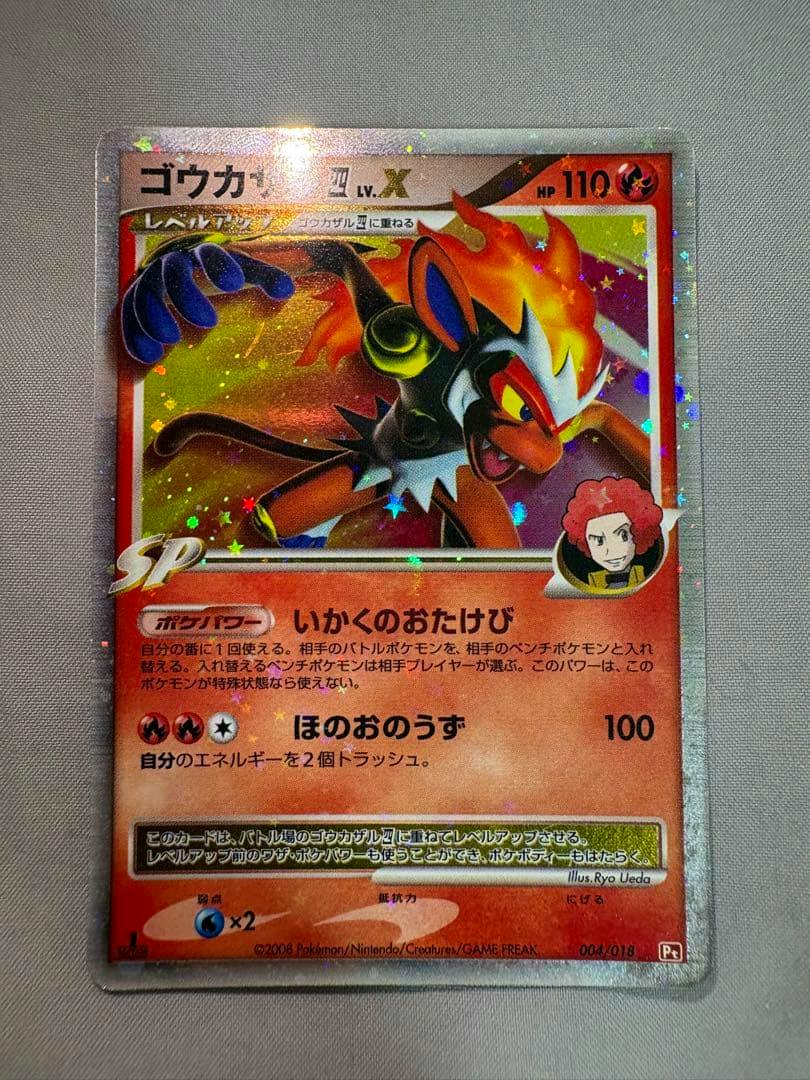 Front-facing photo of the Pokémon trading card 'ゴウカザル四 LV.X' in a protective sleeve on a light fabric background.