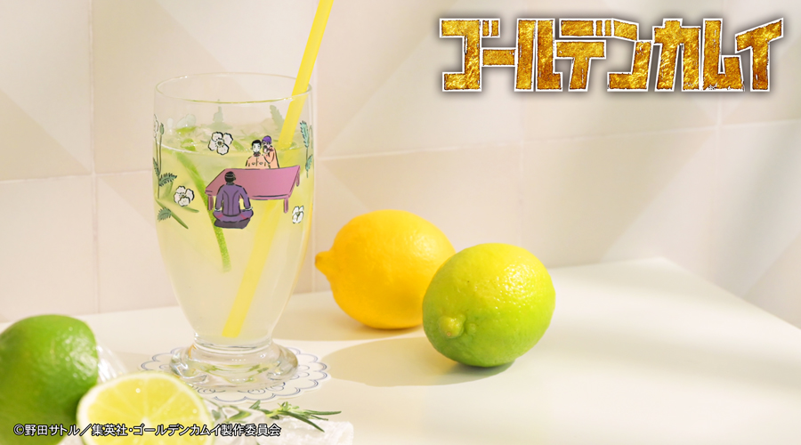 A drinking glass decorated with printed character illustrations and a yellow straw, shown next to lemons.