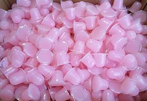 Close-up of numerous small pink cups filled with peach insect jelly.