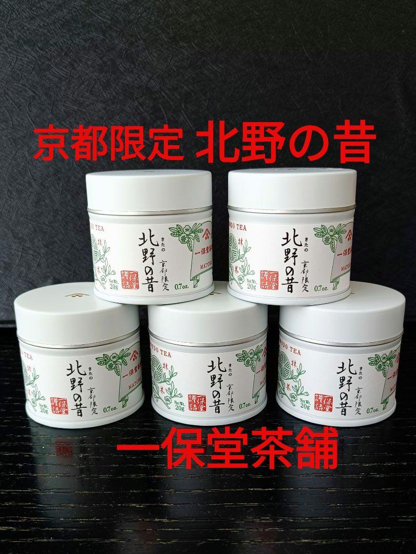 Five white 20g tins of KITANO matcha green tea with Japanese labels arranged on a black surface.