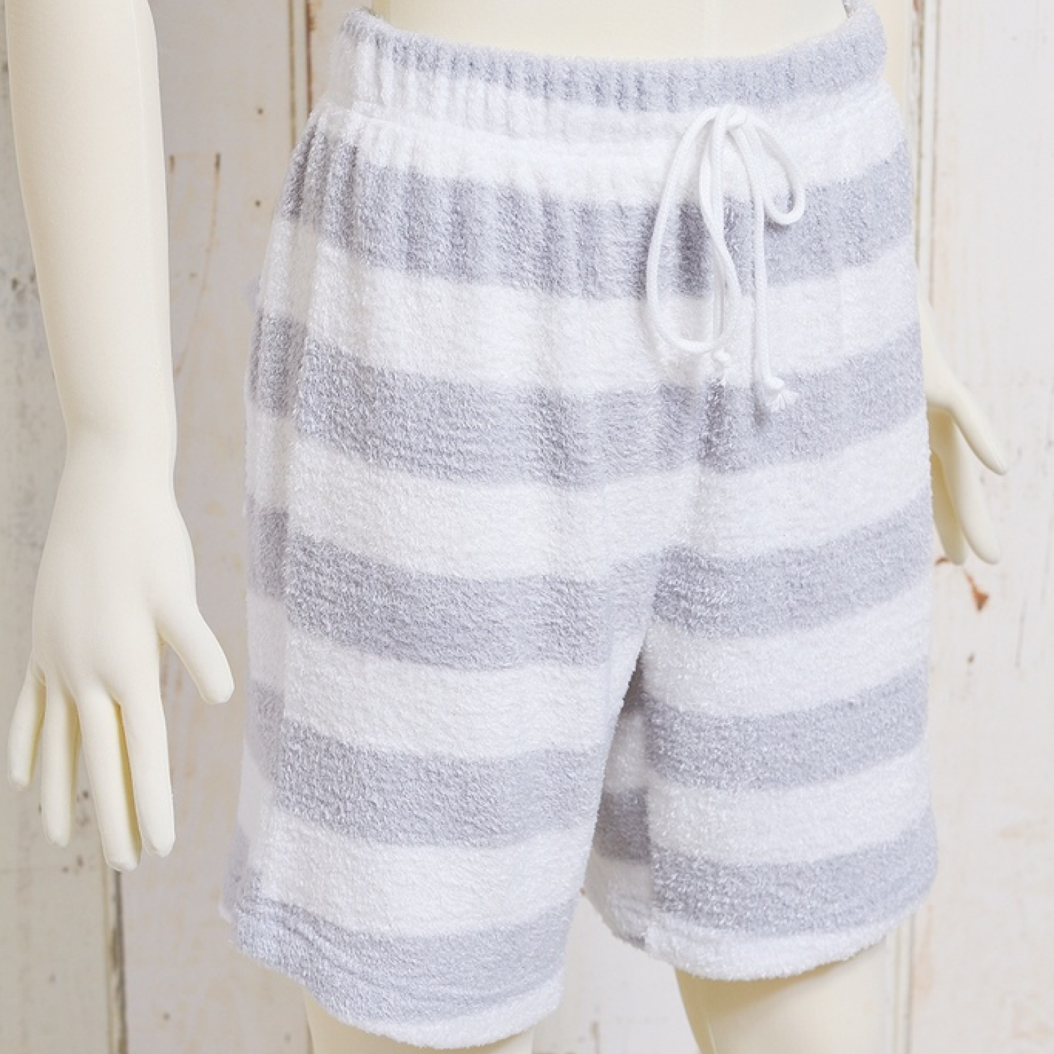 Front view of men's gray-and-white striped pajama shorts on a mannequin showing a drawstring waistband.