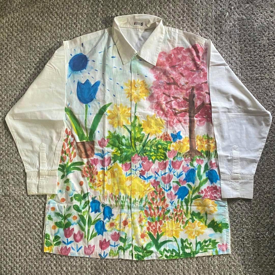 Front view of a men's cotton shirt laid flat showing a hand-painted style colorful floral pattern.