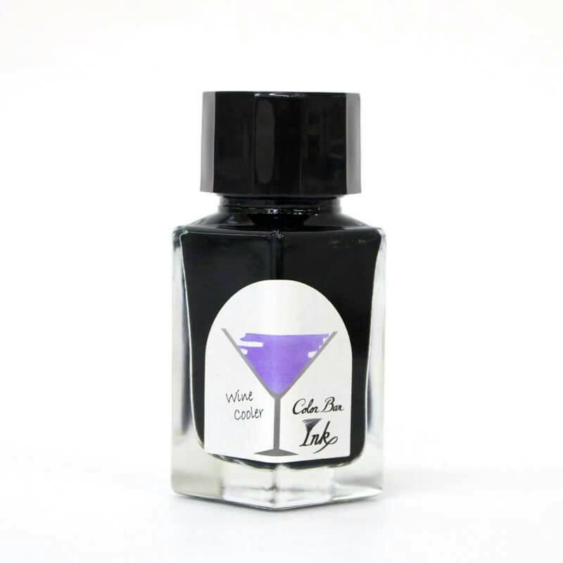 A clear glass bottle of fountain pen ink with a black cap and a label reading “Wine Cooler” on a white background.