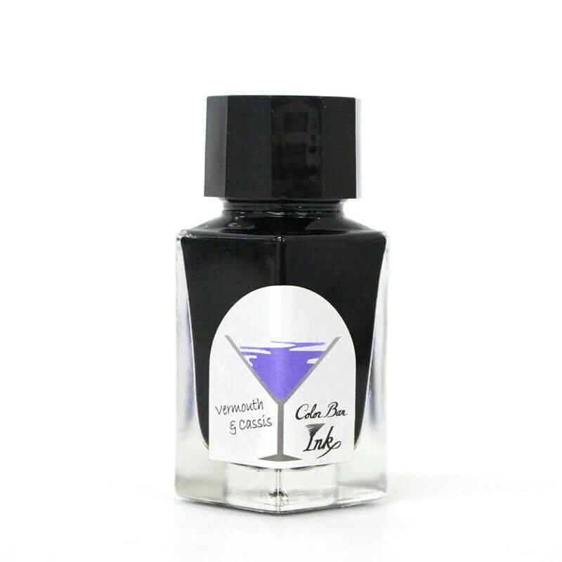 Front view of the bottle of 石丸文行堂 カラーバーインク No.25 「ベルモット&カシス」 fountain pen ink, showing a clear glass bottle with a black cap and a front label depicting a purple cocktail graphic.
