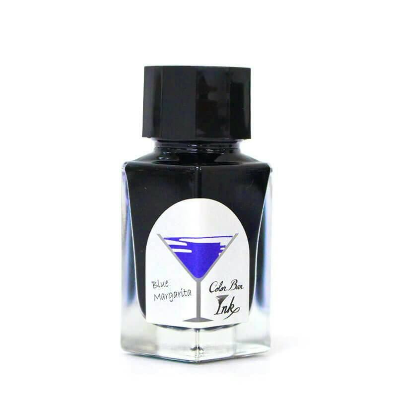 A clear glass bottle of fountain pen ink with a black cap and a label showing a blue martini glass and the text "Blue Margarita" and "Color Bar Ink".