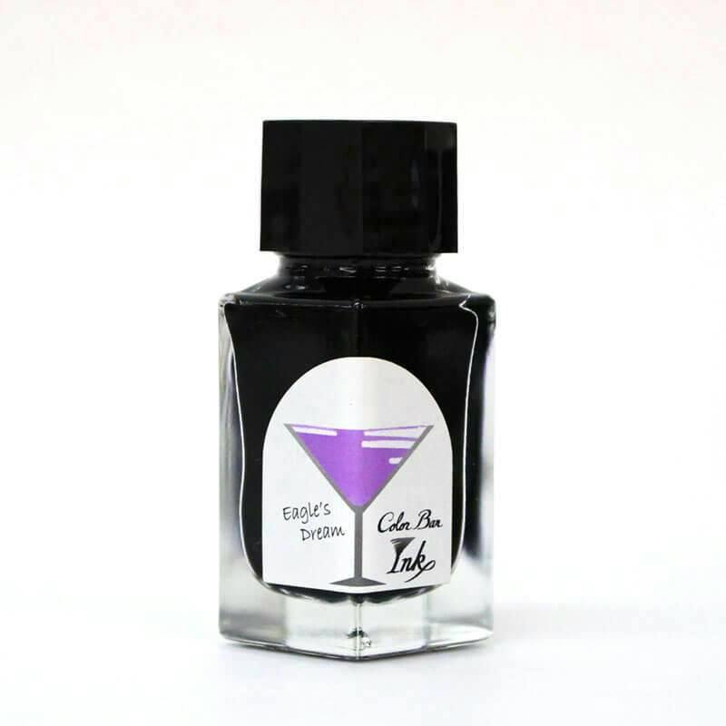 Front view of a fountain pen ink bottle showing a clear glass bottle labeled "Eagle's Dream" with a purple cocktail-glass graphic and Color Bar Ink text.