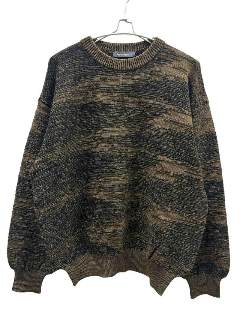 Front view of a brown Issey Miyake wool sweater with a textured marled knit hanging on a hanger against a white background.