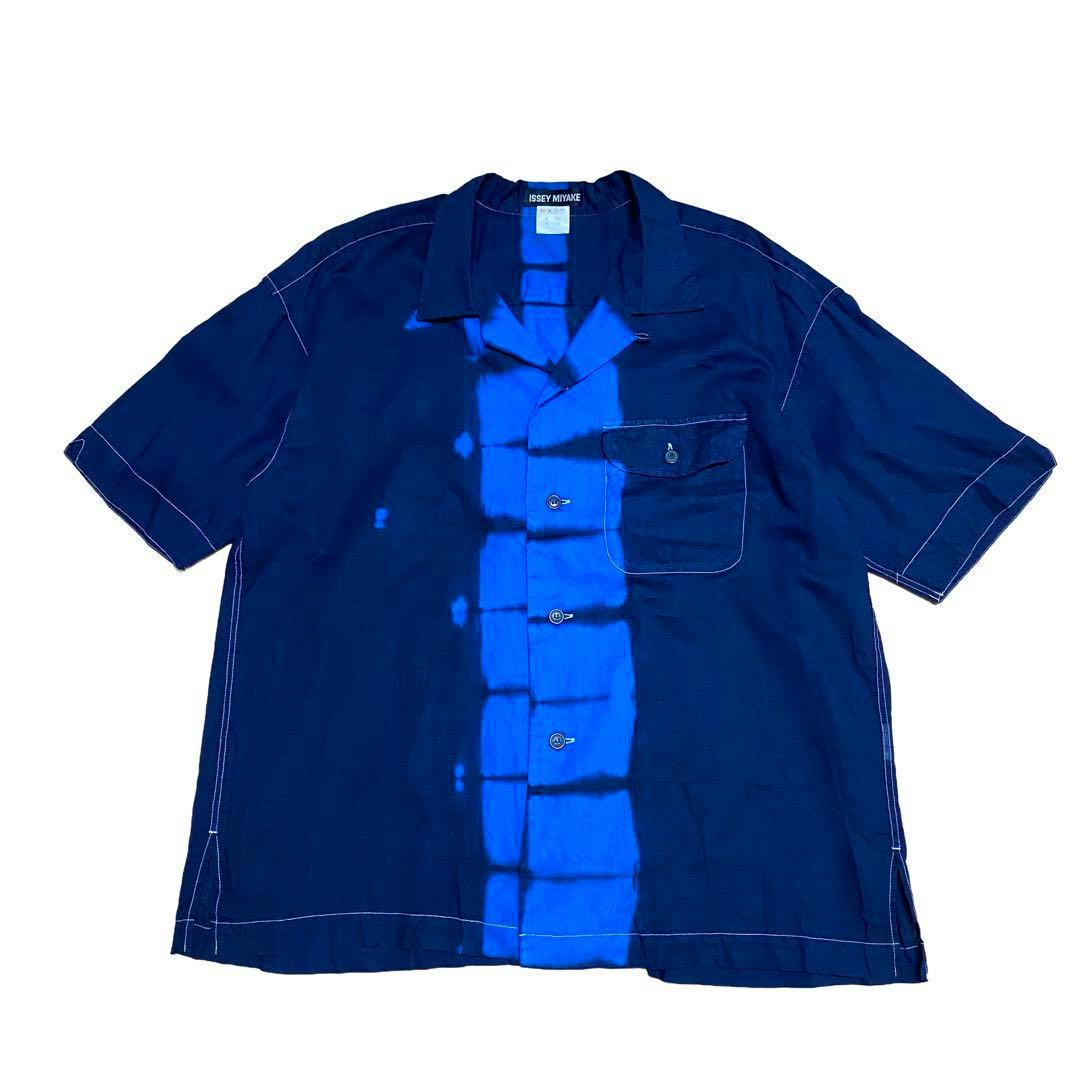 Front view of a men's ISSEY MIYAKE open-collar short-sleeve shirt in dark navy with a central bright blue tie-dye vertical stripe and a chest pocket.