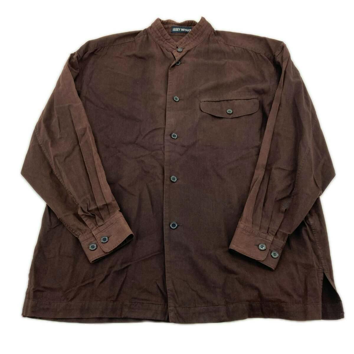 Brown long-sleeve band-collar men's shirt (ISSEY MIYAKE) laid flat showing the front, buttons, cuffs, and chest pocket.