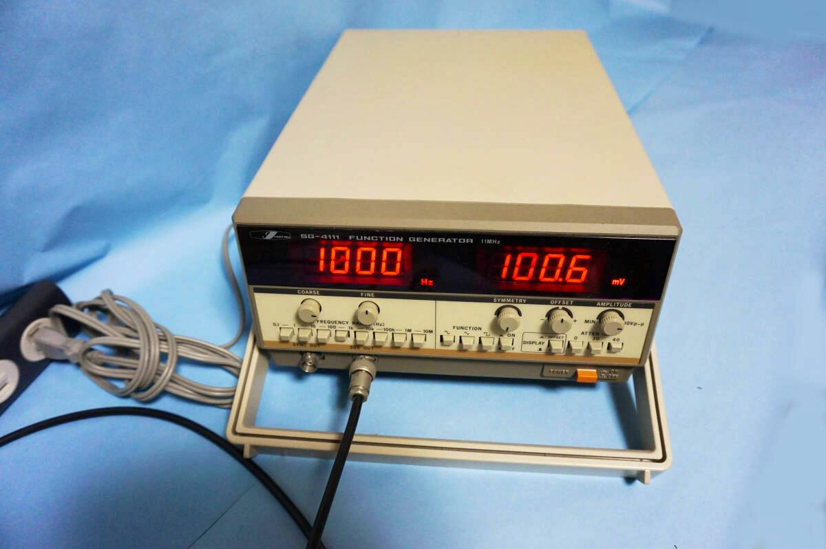 Front view of the 岩崎通信機 SG-4111 function generator showing its numeric displays, control knobs, and front BNC connector.