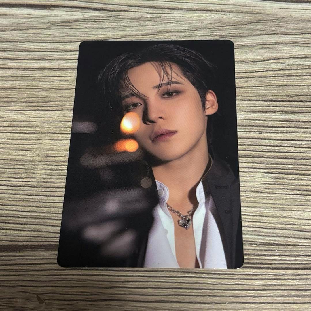 Photocard front showing a close-up portrait of the artist placed on a wood surface.