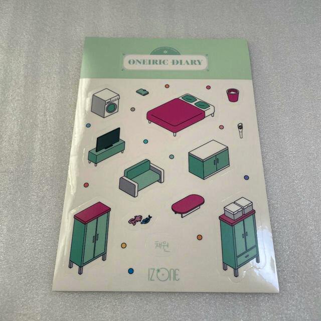 Photograph of an IZONE ONEIRIC DIARY sticker sheet showing small furniture illustrations, the ONEIRIC DIARY header, and the IZ*ONE logo.