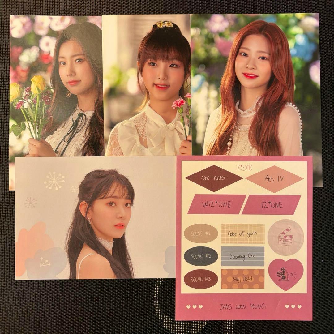 Several IZ*ONE postcards arranged on a dark textured background showing member portrait photos and a decorative card.