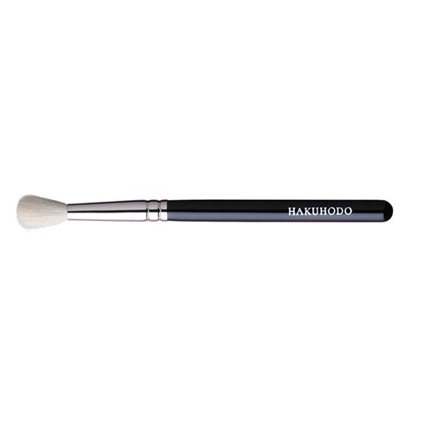 A HAKUHODO eyeshadow brush with a black handle and round white bristles on a white background.