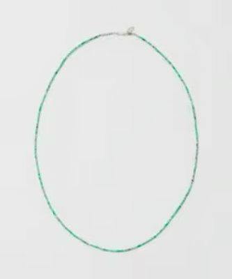 Green jade bead necklace laid flat on a plain background.