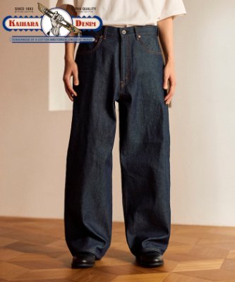 Front view of men's wide-leg dark denim five-pocket pants worn by a model.
