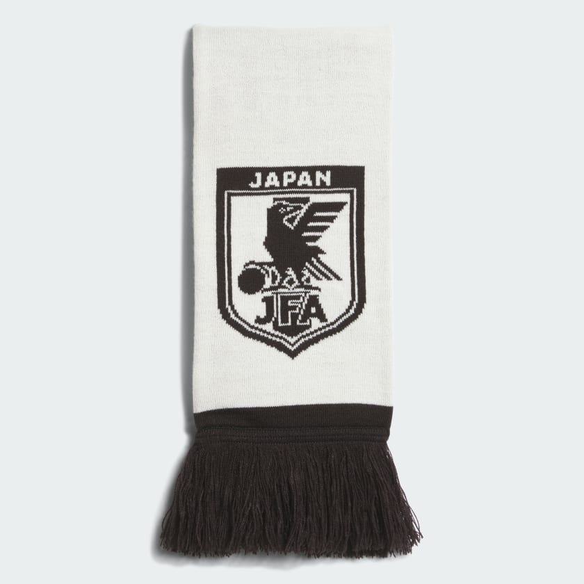 A white and black acrylic Japan national team scarf folded to show the JFA crest and black fringed ends.