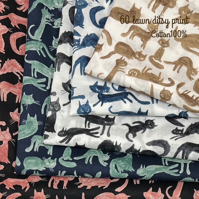Folded cotton fabric pieces showing cat print patterns in several colors.