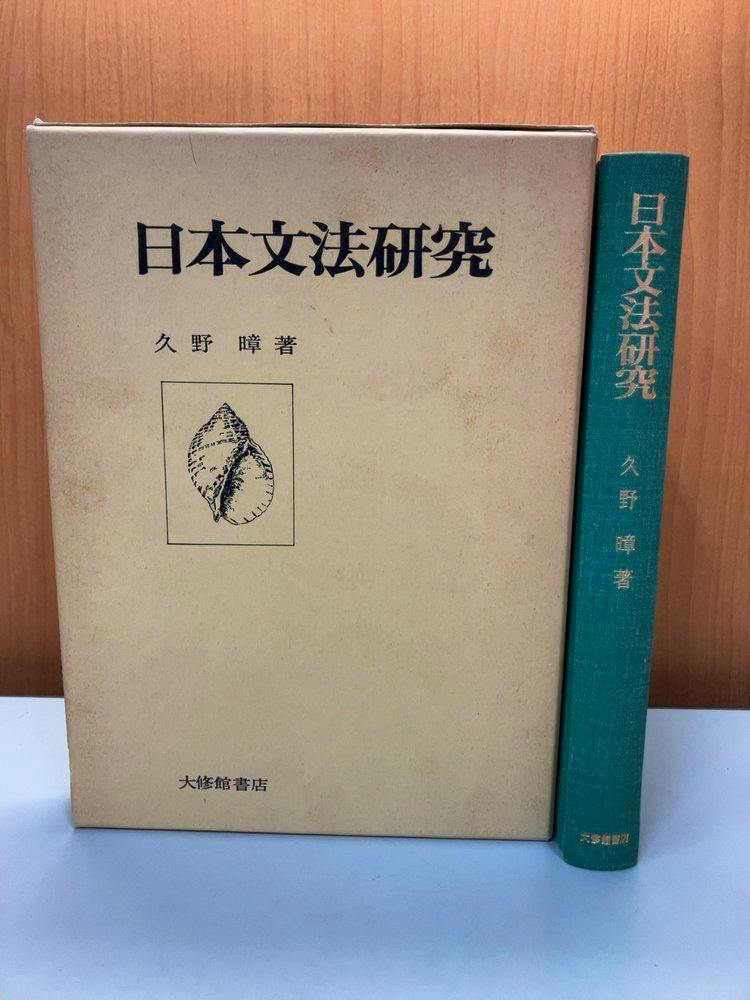 Front cover and teal cloth spine of the book 日本文法研究 with its slipcase standing on a light surface against a wooden background.