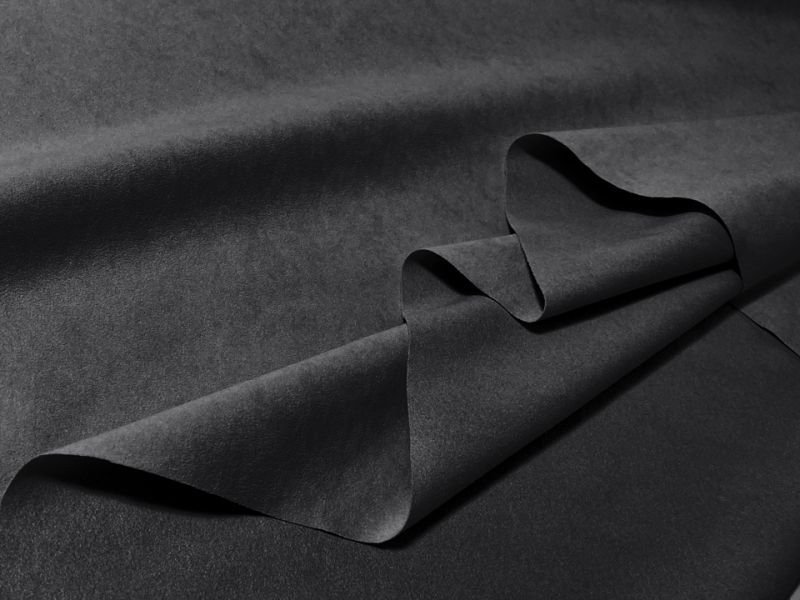Folded dark black-to-dark-gray suede-like artificial leather fabric (polyester) shown flat.