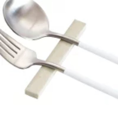 Ceramic chopstick/cutlery rest with a fork and spoon on a white background.
