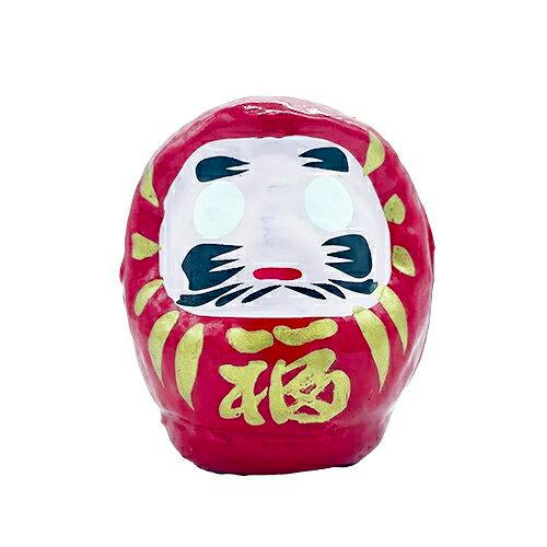Red daruma ornament with a white face, black facial markings, and a gold “福” character on the front.