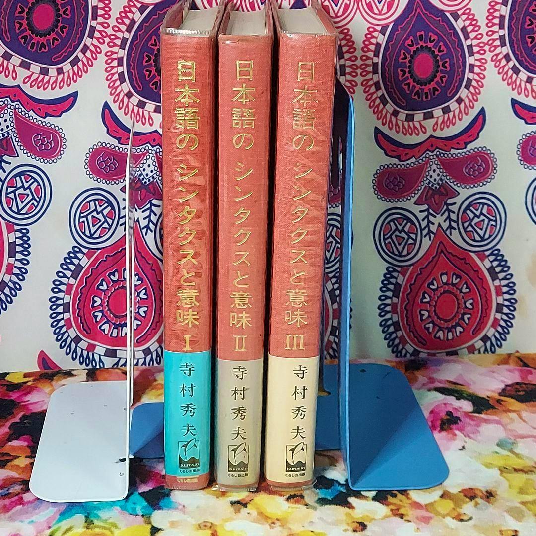 Three hardcover volumes of the Japanese book set "日本語のシンタクスと意味" (volumes I–III) standing upright showing their spines between bookends.