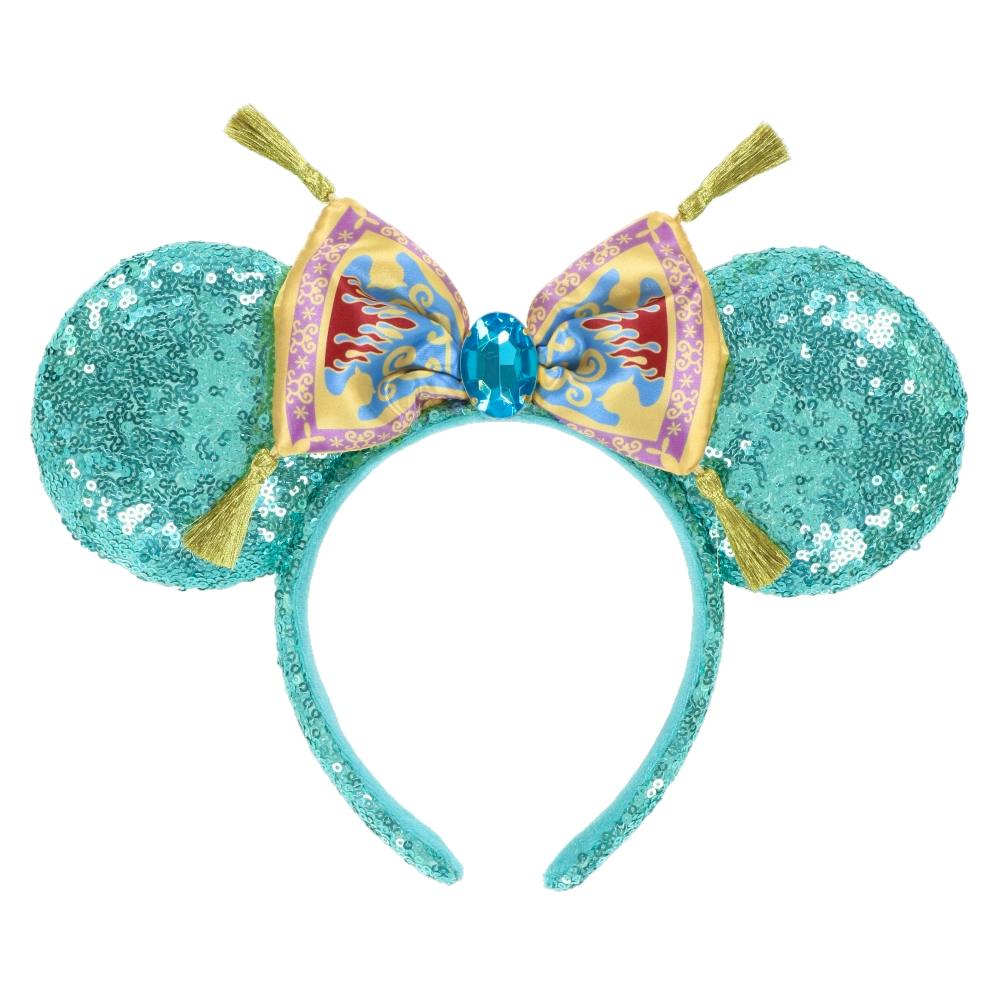 Teal sequin headband with round ears, a patterned bow, gold tassels, and a central blue jewel.
