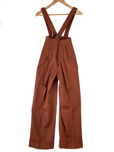 Brown pants with attached suspenders hanging on a wooden hanger, front view.