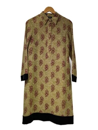 Front view of the Jean Paul GAULTIER FEMME women's polyester dress with a repeating floral motif and black cuffs and hem, hanging on a wooden hanger.