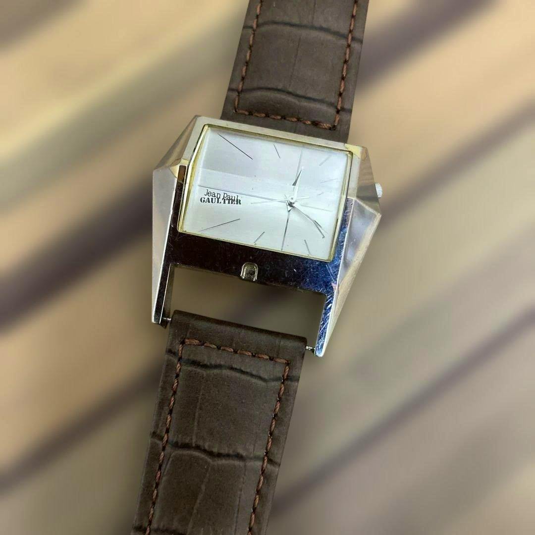 Close-up of the Jean Paul GAULTIE square wristwatch showing its square silver case, face, and brown new strap.