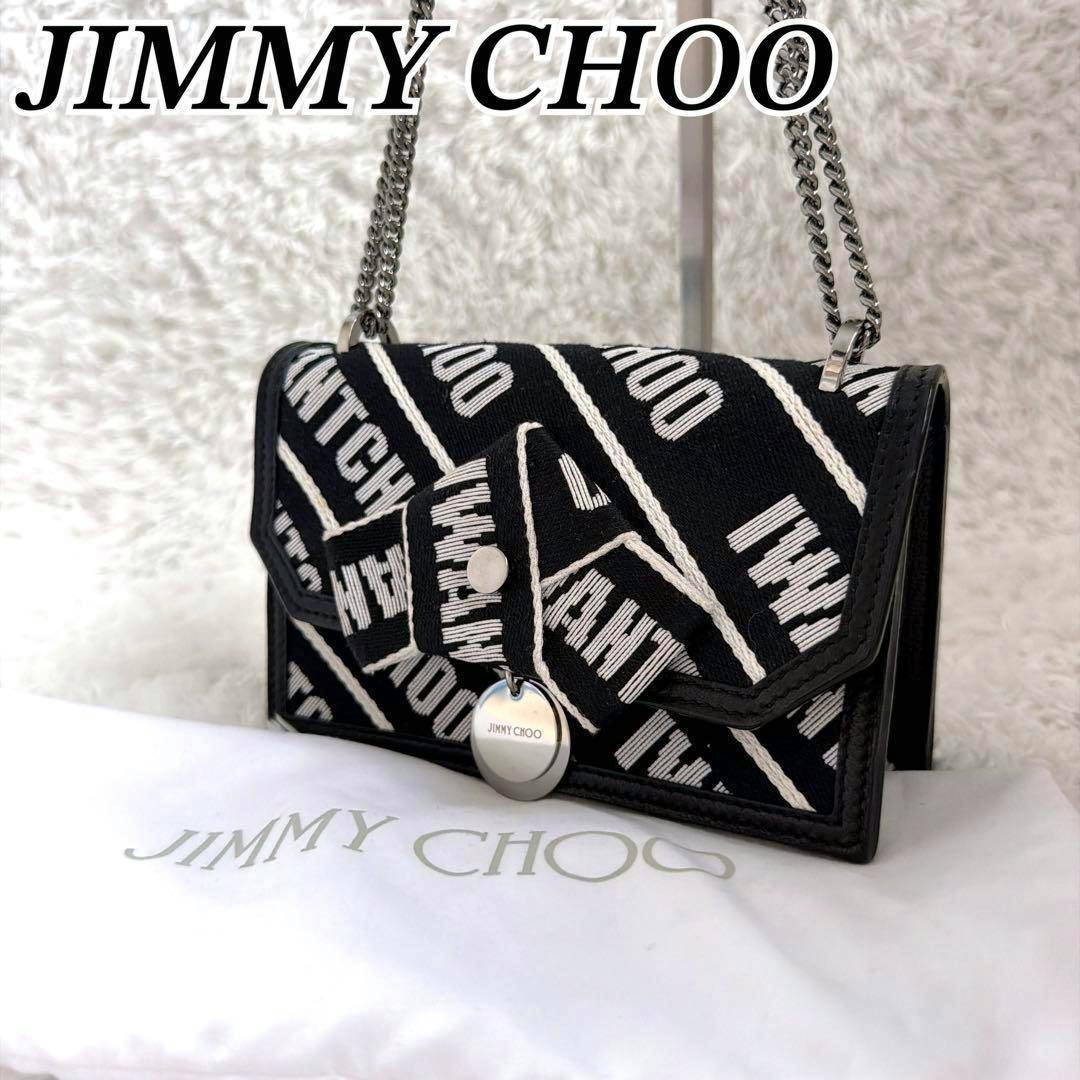 Front view of the black Jimmy Choo canvas chain shoulder bag with white diagonal logo pattern, leather trim, and round metal clasp.