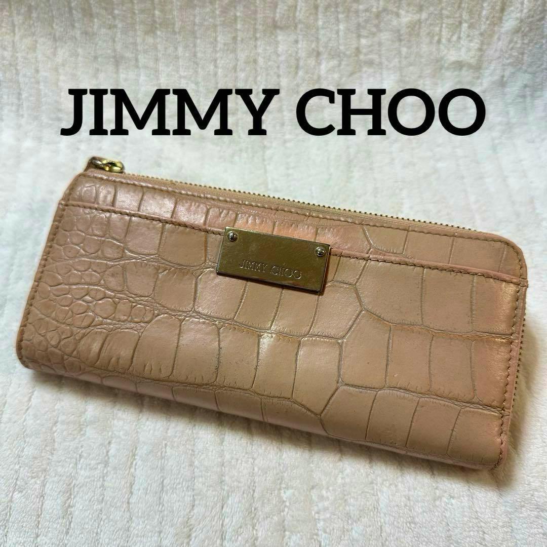 Beige crocodile‑embossed leather long wallet with an L‑shaped zipper and a gold Jimmy Choo logo plate on a light background.